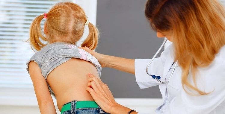 the doctor examines the child's back for lower back pain